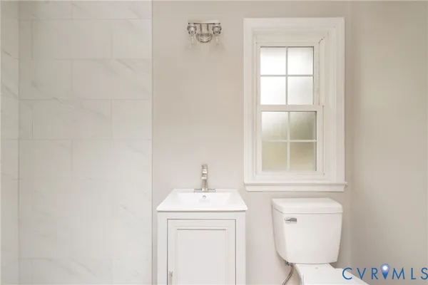 a bathroom with a toilet a sink and a window