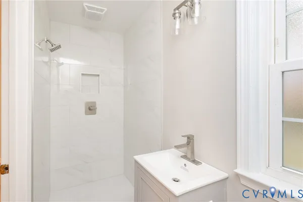 a bathroom with a sink a mirror and shower