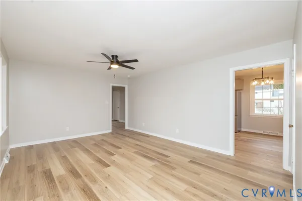 a view of a room with wooden floor and a ceiling fan