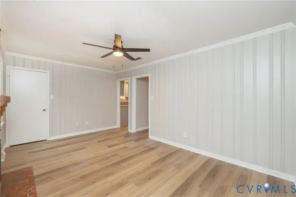 a view of a room with wooden floor and ceiling fan