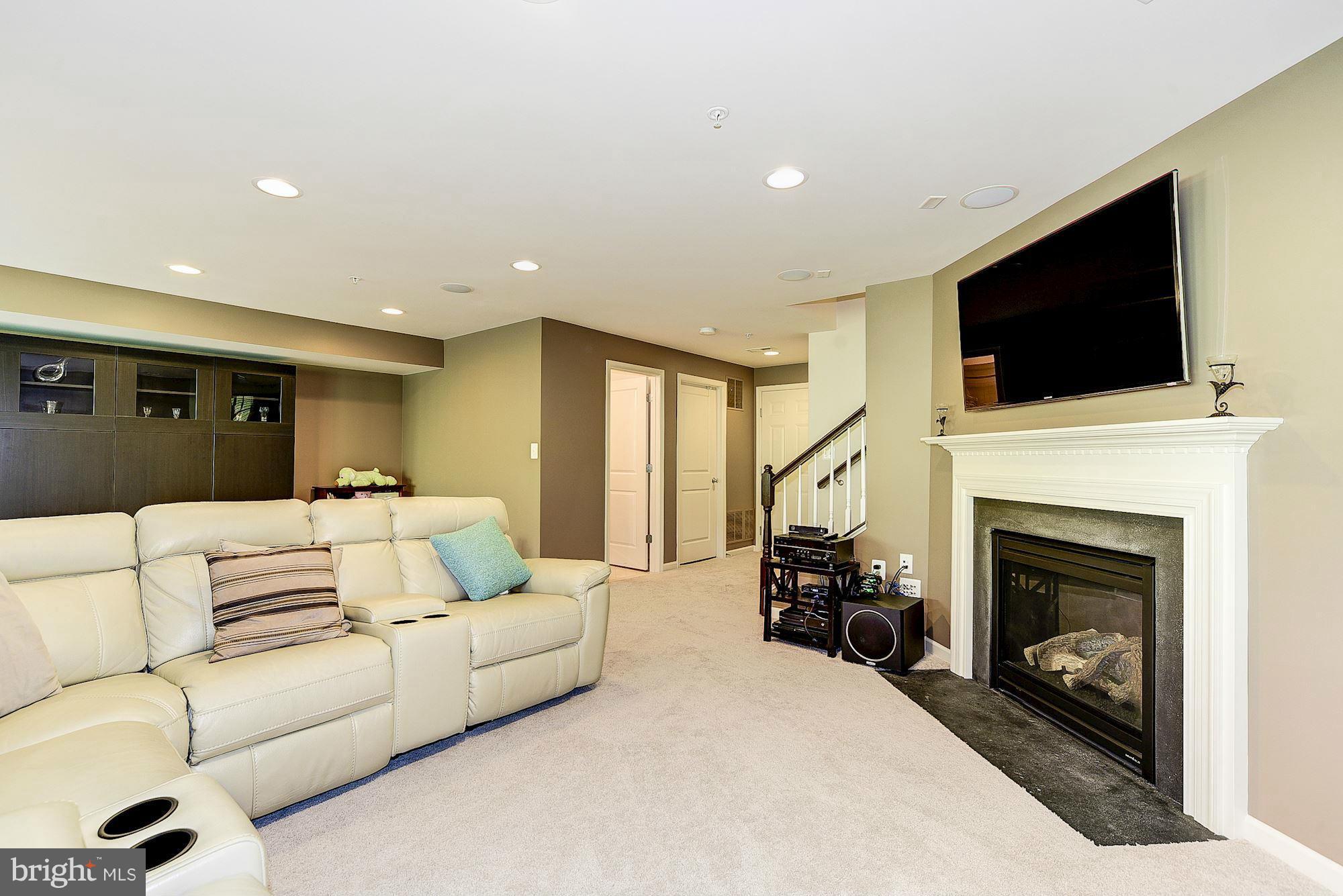 1525 Rabbit Hollow Place Silver Spring, MD 20906 - Photo 23 of 30 a living room with furniture a fireplace and a flat screen tv