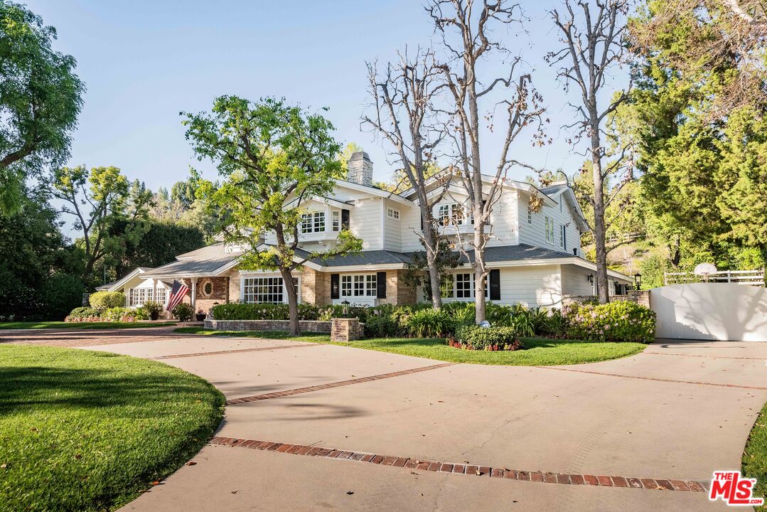 23939 Long Valley Road Hidden Hills, CA 91302 - Photo 1 of 61 a front view of a house with a garden and trees