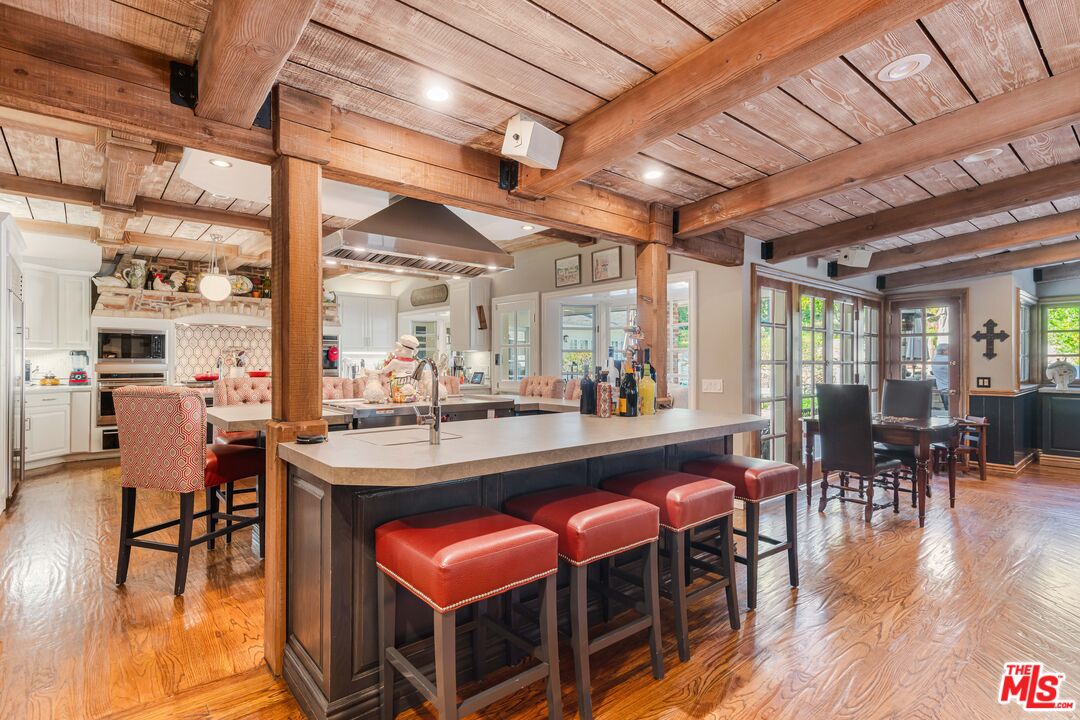 23939 Long Valley Road Hidden Hills, CA 91302 - Photo 30 of 61 a dining hall with stainless steel appliances granite countertop a table chairs and a wooden floor