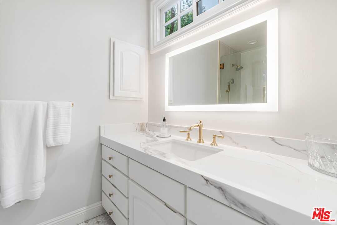 23939 Long Valley Road Hidden Hills, CA 91302 - Photo 40 of 61 a bathroom with a sink and a mirror