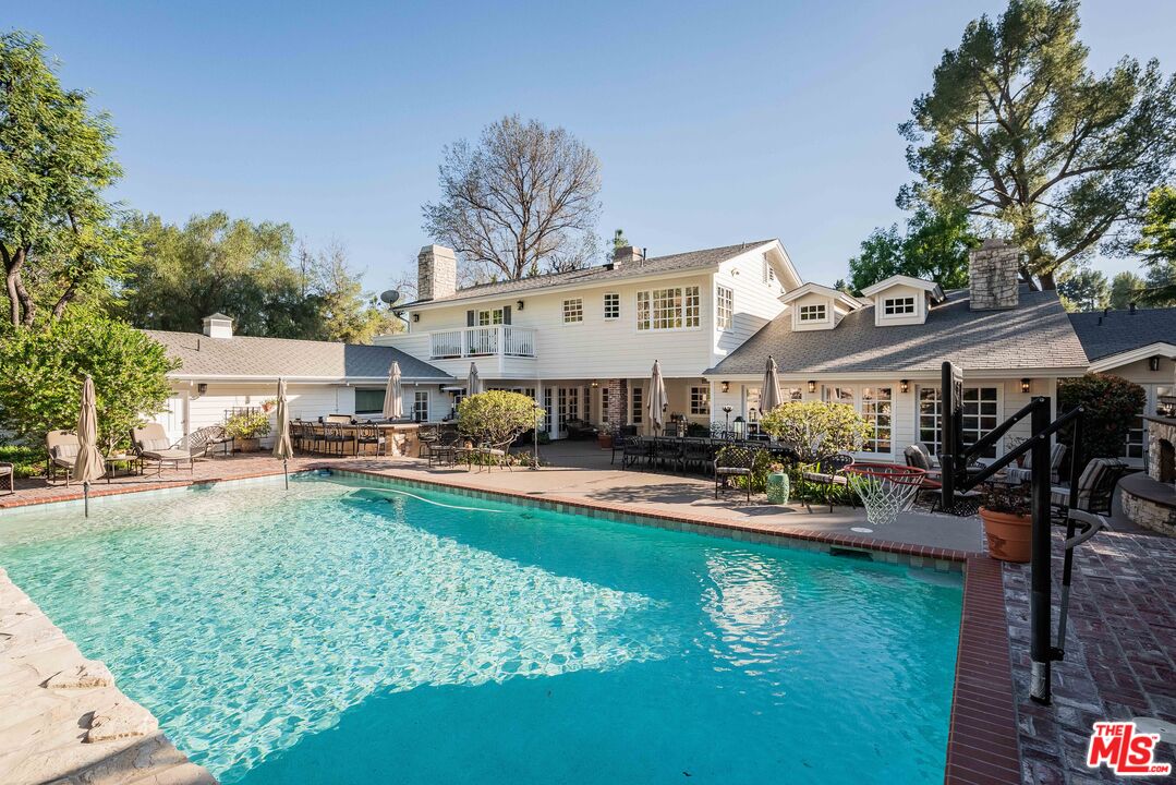 23939 Long Valley Road Hidden Hills, CA 91302 - Photo 5 of 61 a front view of a house with swimming pool garden and patio