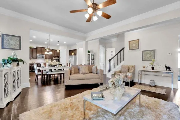 a living room with furniture kitchen view and a chandelier