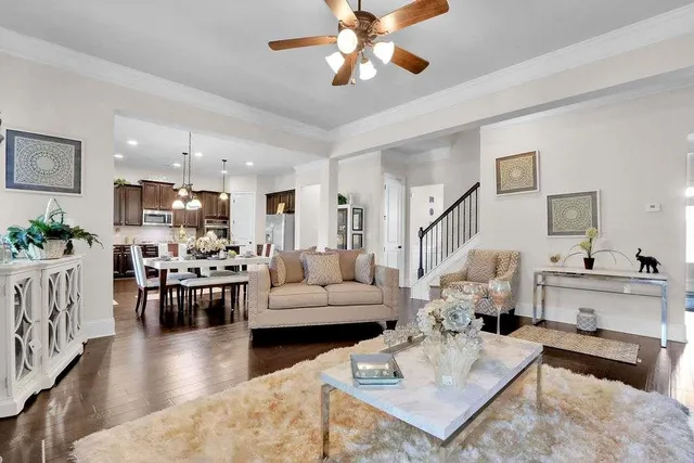 a living room with furniture kitchen view and a chandelier