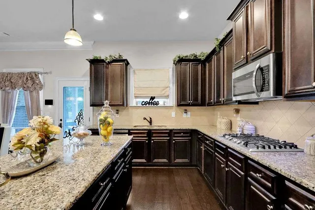 a kitchen with stainless steel appliances granite countertop a sink stove and cabinets