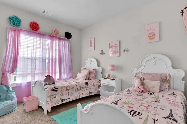 a bedroom with two beds and a window