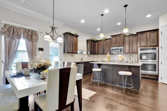 a kitchen with kitchen island granite countertop wooden floors and white cabinets