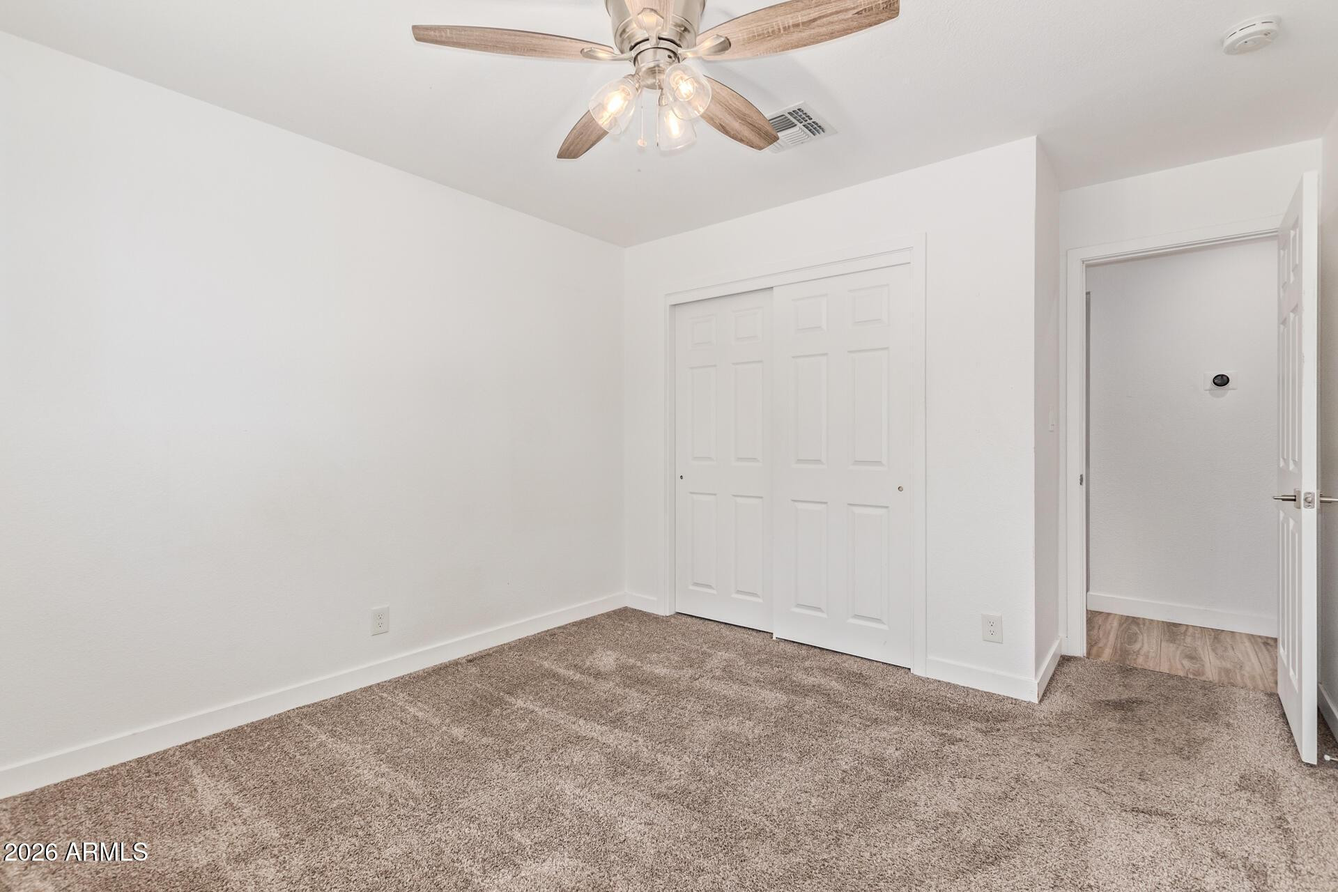 1809 East Concorda Drive Tempe, AZ 85282 - Photo 13 of 23 an empty room with a chandelier fan and closet