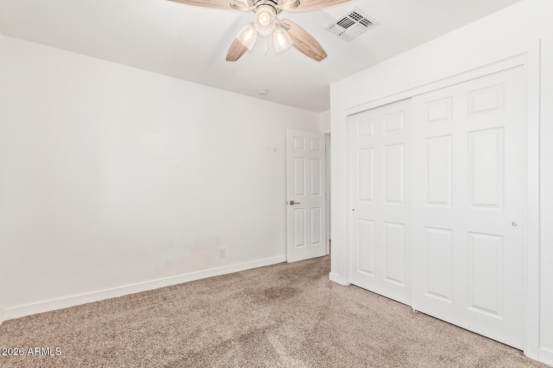 1809 East Concorda Drive Tempe, AZ 85282 - Photo 15 of 23 an empty room with a chandelier fan and wooden floor