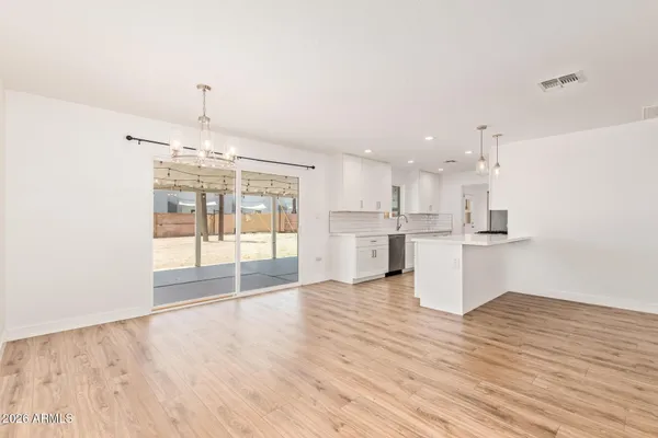 a view of a kitchen with kitchen island wooden floor and stainless steel appliances