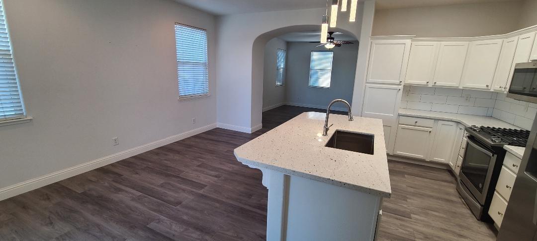 1611 North Monaco Lane Clovis, CA 93619 - Photo 5 of 16 a kitchen with a sink a microwave and cabinets