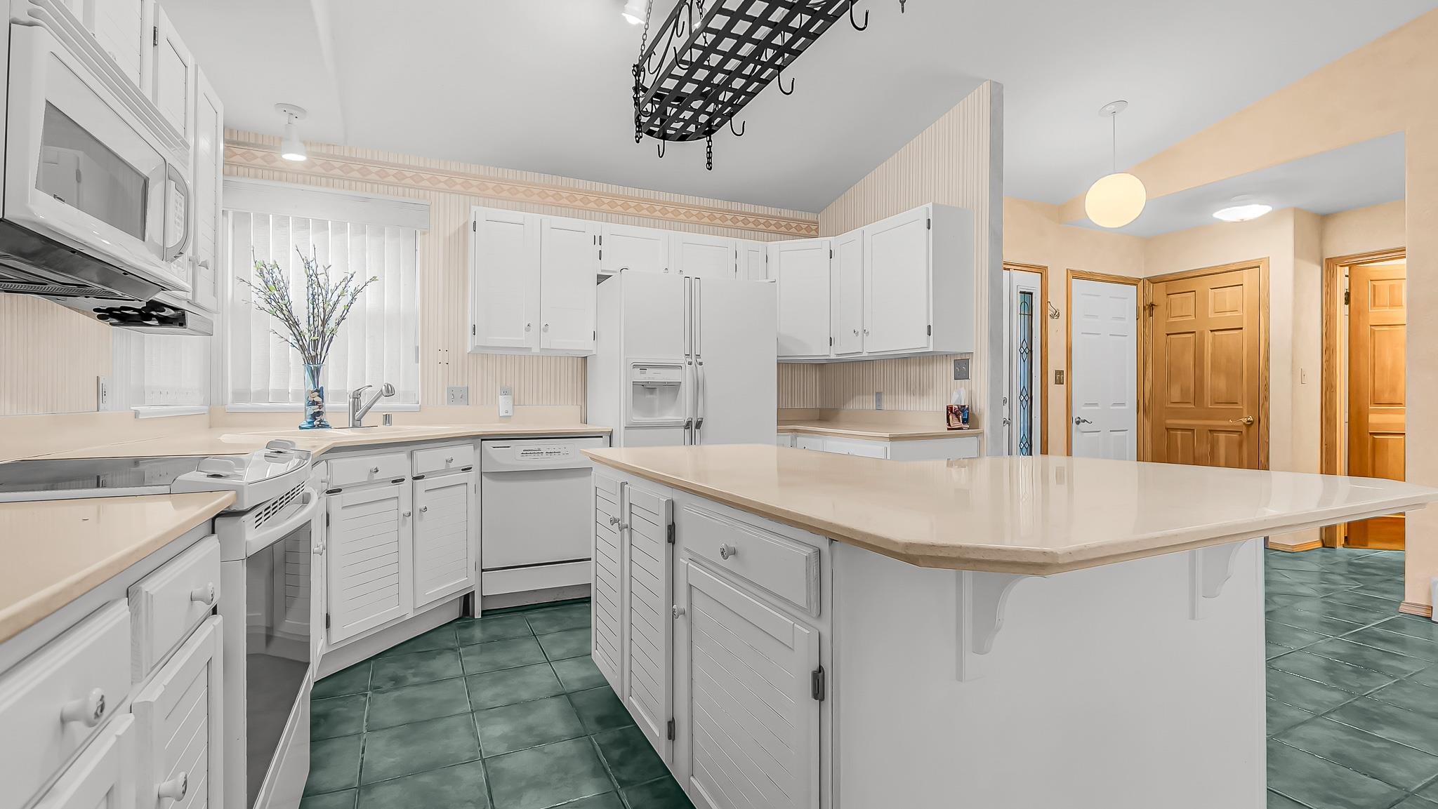 12 West Ridge Court Parachute, CO 81635 - Photo 8 of 37 a kitchen with white cabinets appliances a sink and a window