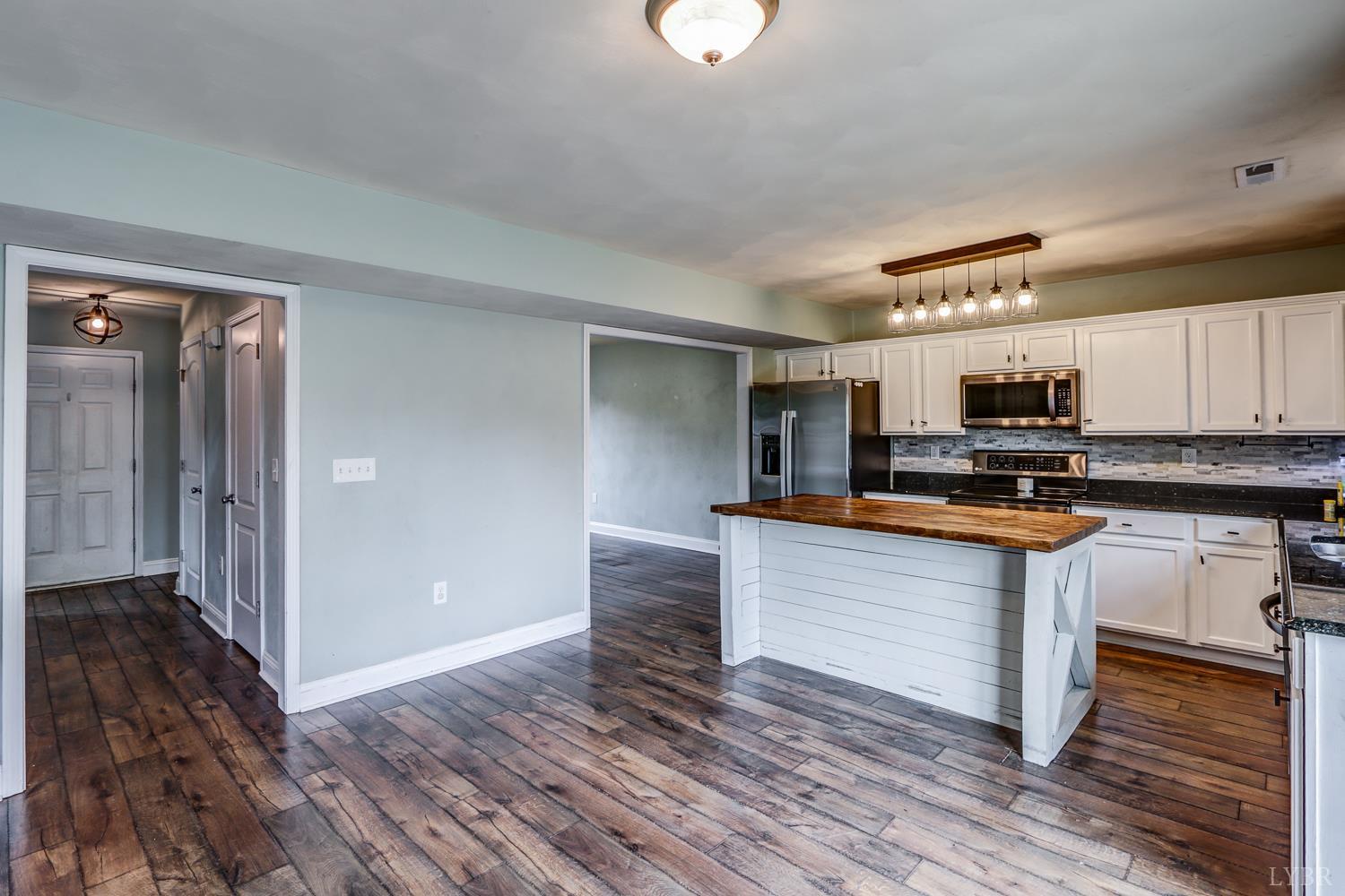 1057 Old Trail Road Forest, VA 24551 - Photo 13 of 49 a kitchen with granite countertop wooden floors and stainless steel appliances