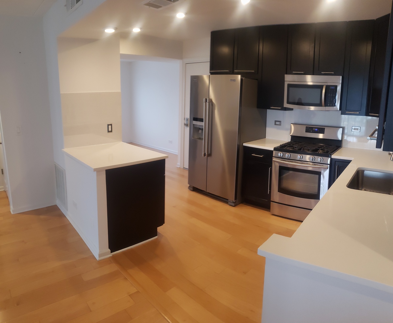 8350 West Addison Street, Unit 201 Chicago, IL 60634 - Photo 7 of 41 a kitchen with kitchen island a sink stainless steel appliances and cabinets