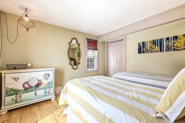 a bedroom with a bed and painting on the wall