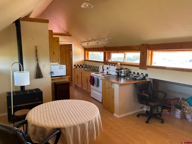 a kitchen with a table chairs refrigerator and window