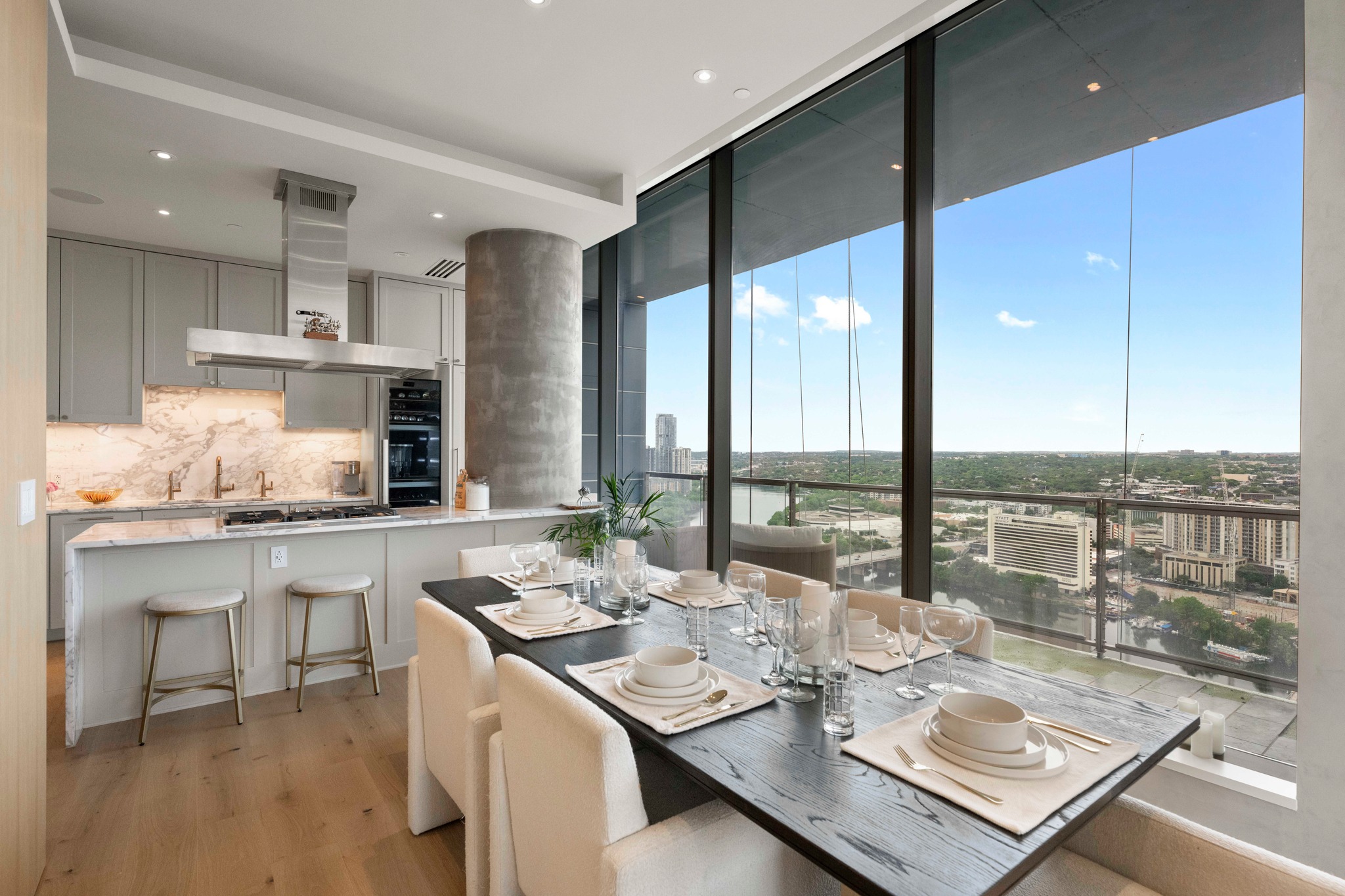 210 Lavaca Street, Unit 2706 Austin, TX 78701 - Photo 20 of 32 Open-concept kitchen and dining area featuring floor-to-ceiling windows, light wood-finish flooring, a contemporary kitchen with light grey cabinetry, a stone backsplash, and a built-in oven