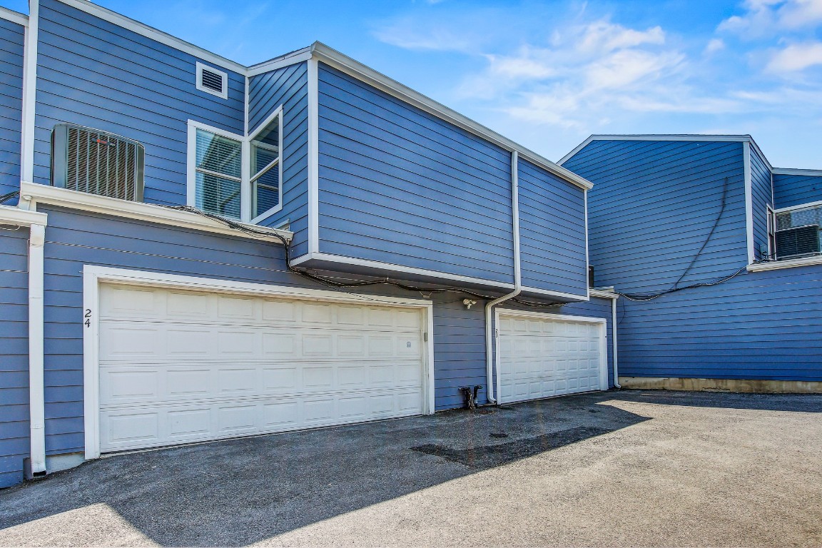 1010 West Rundberg Lane, Unit 24 Austin, TX 78758 - Photo 22 of 24 Garage featuring asphalt driveway