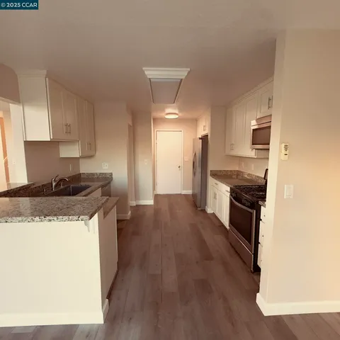 a kitchen with granite countertop a sink and a stove top oven