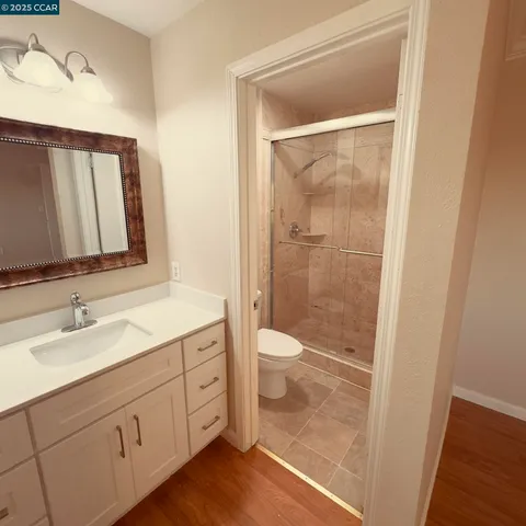 a bathroom with a granite countertop sink toilet and shower