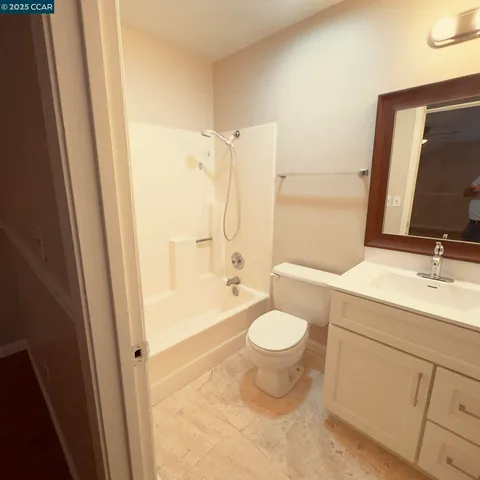 a bathroom with a sink a toilet and shower a mirror