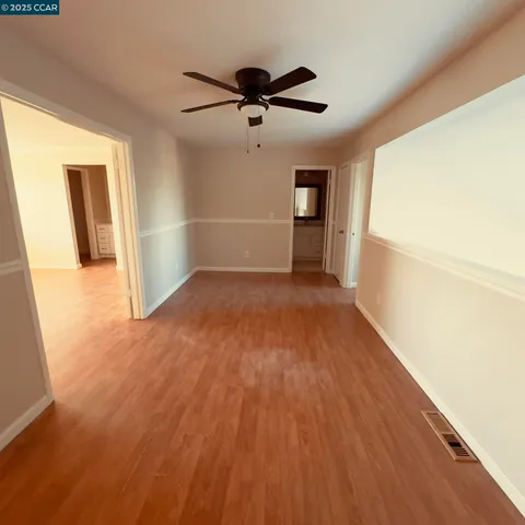 a view of a livingroom with wooden floor and a ceiling fan