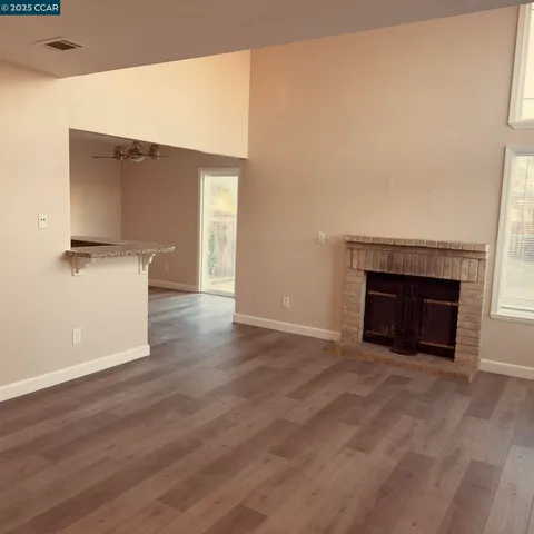 a view of empty room with wooden floor and fireplace