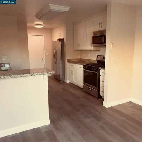 a kitchen with stainless steel appliances granite countertop a stove a sink and a refrigerator