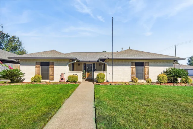 a front view of a house with a garden and yard