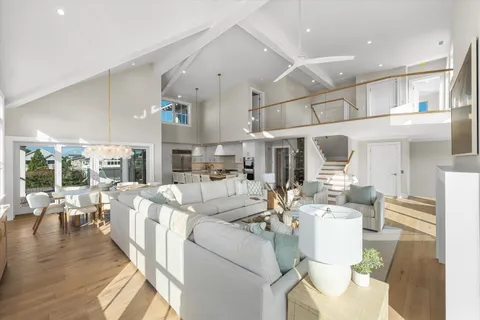 a living room with furniture wooden floor and a large window