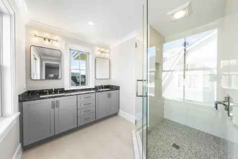 a large bathroom with a double vanity sink a mirror and a shower