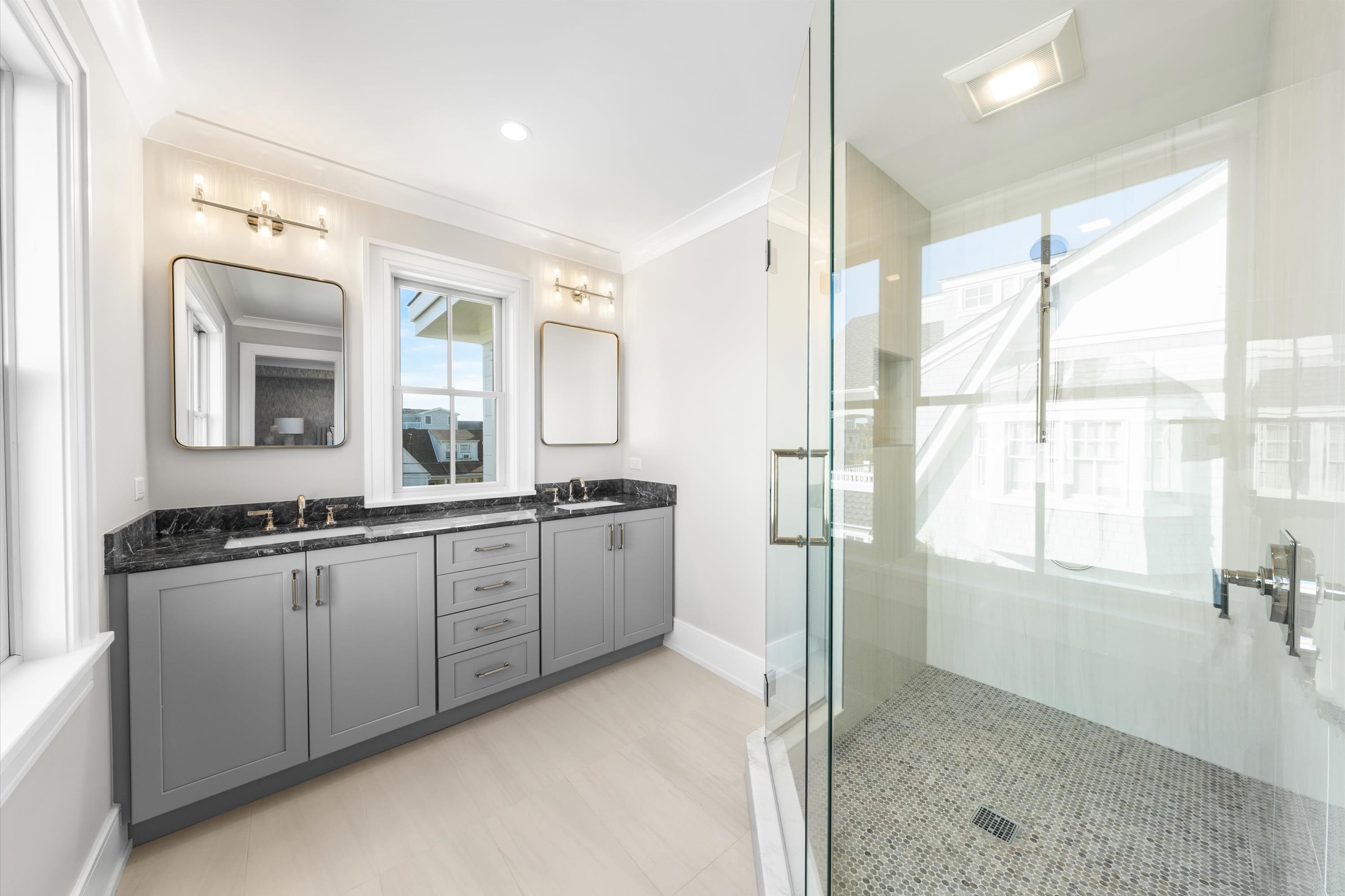 245 57th Street Avalon, NJ 08202 - Photo 23 of 50 a large bathroom with a double vanity sink a mirror and a shower