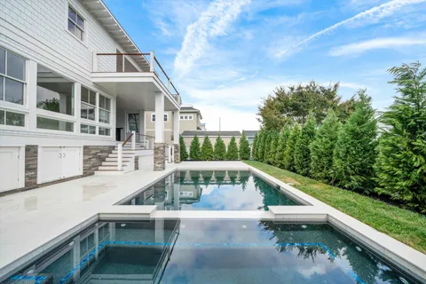 a view of house with swimming pool and outdoor seating