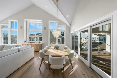 a dining room with furniture large windows and wooden floor