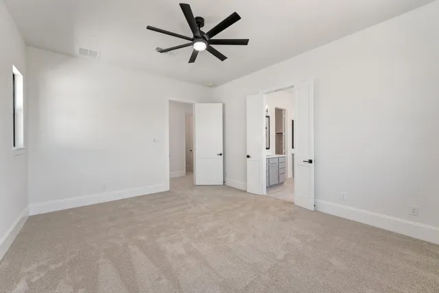 an empty room with closet and a ceiling fan