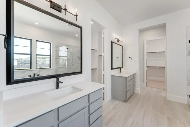 a bathroom with a double vanity sink a mirror and a bathtub