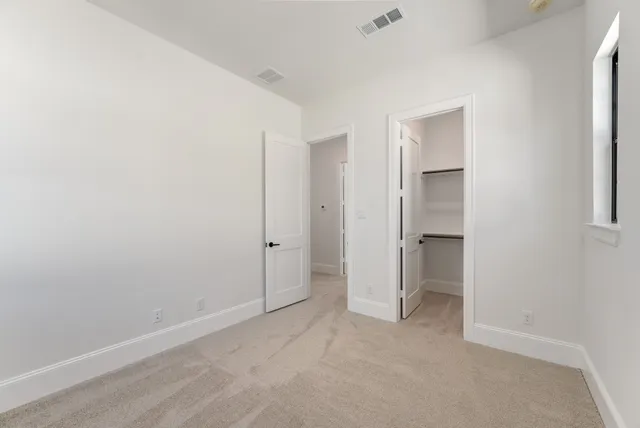 an empty room with closet and a bathroom