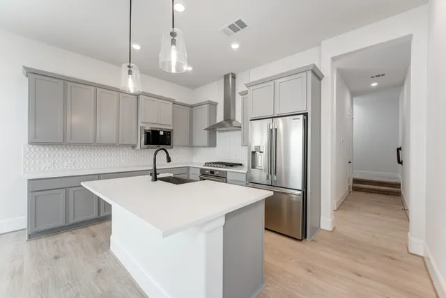 a kitchen with a refrigerator a sink and cabinets