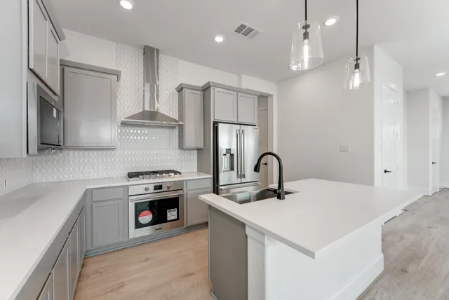 a kitchen with stainless steel appliances granite countertop a sink stove and refrigerator