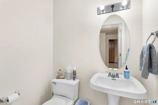 a bathroom with a toilet sink and mirror