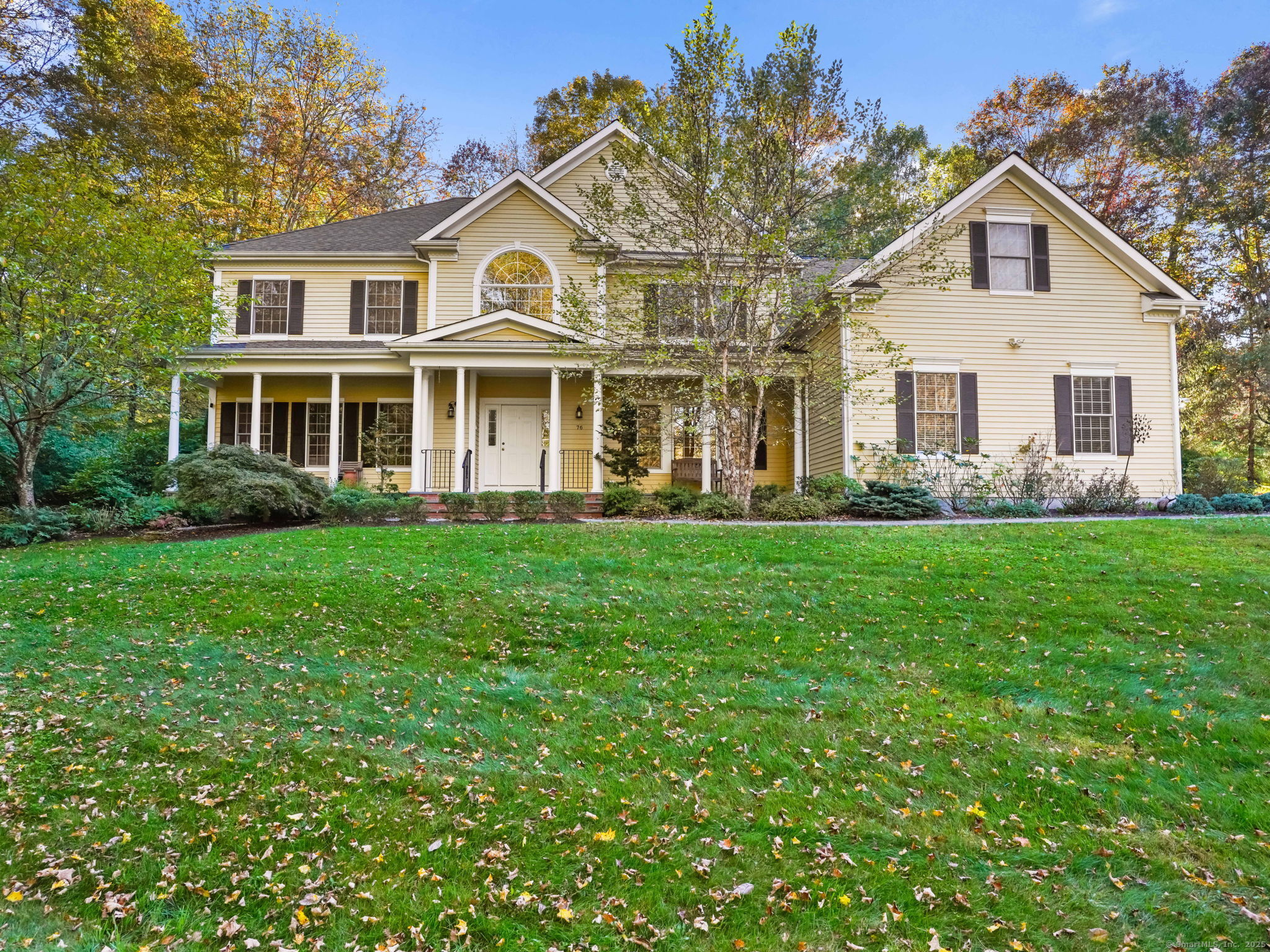 a front view of a house with garden and trees
