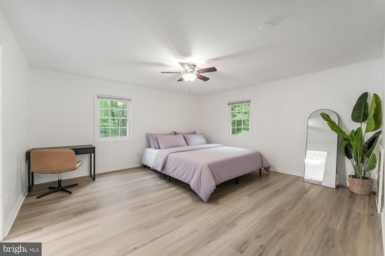 11621 Sourwood Lane Reston, VA 20191 - Photo 12 of 26 a spacious bedroom with a bed a chandelier and a window