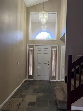 a view of a hallway with windows and chandelier