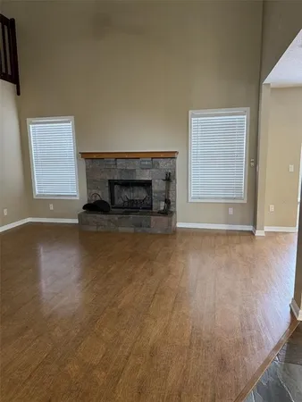 an empty room with floor to ceiling window and fireplace