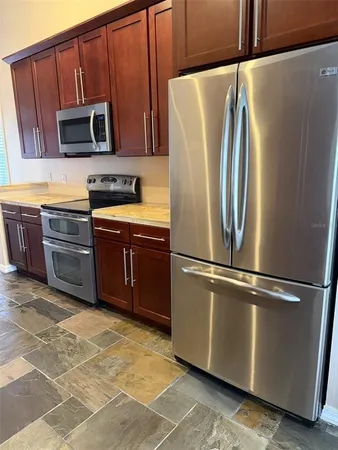 a kitchen with stainless steel appliances granite countertop a refrigerator stove and microwave