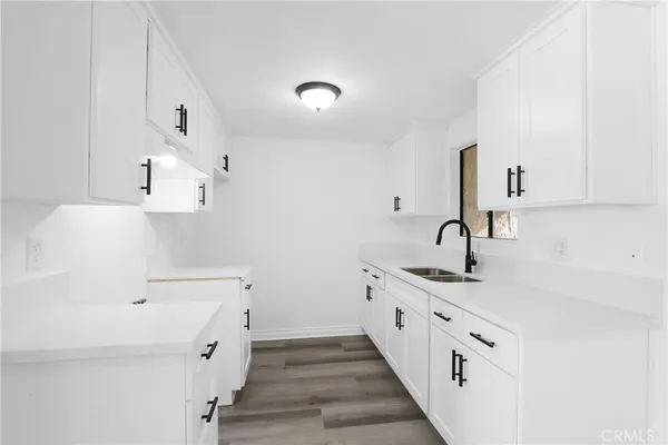a kitchen with white cabinets sink and stove