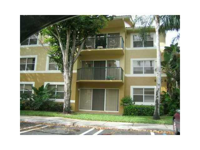 8977 Wiles Road, Unit 2105 Coral Springs, FL 33067 - Photo 2 of 7 a front view of a house with a yard